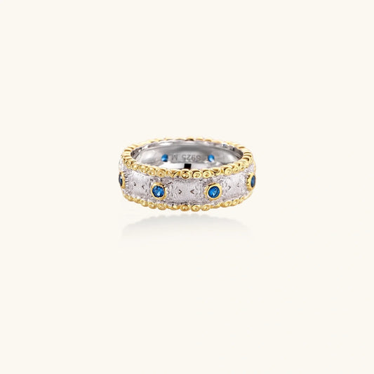 Elegant two-tone ring with blue gemstones and textured design