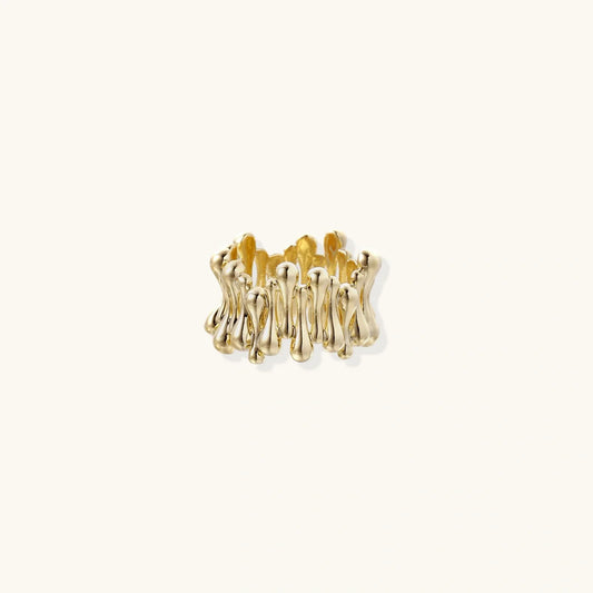 Gold sculptural ring with organic, fluid design on minimalist background