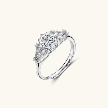 Sterling silver ring with oval moissanite center stone surrounded by smaller accent stones in ornate setting