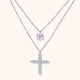 Two delicate sterling silver necklaces with moissanite stones - one solitaire pendant and one cross pendant on white background.