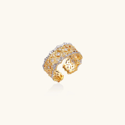 Two-tone ring with geometric lattice pattern in gold and silver finish with crystal accents on beige background